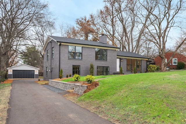 view of front of house with a front yard, a garage, and an outdoor structure