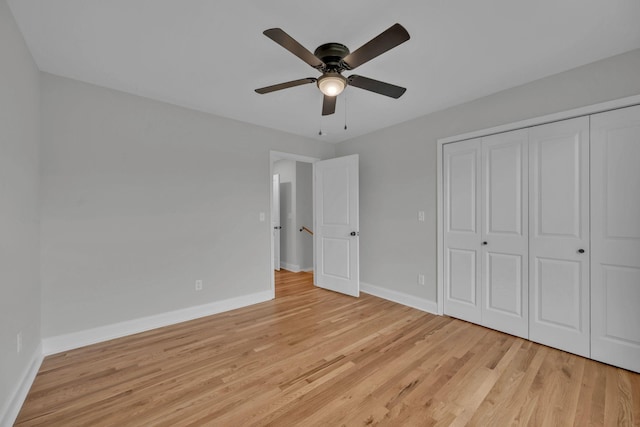 unfurnished bedroom featuring light wood-style flooring, baseboards, a closet, and ceiling fan