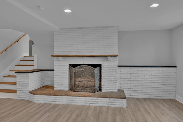 details featuring recessed lighting, a brick fireplace, and wood finished floors