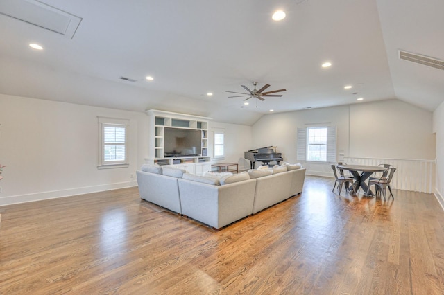 living room featuring light wood-type flooring, vaulted ceiling, and ceiling fan