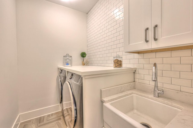 clothes washing area with sink, cabinets, and independent washer and dryer