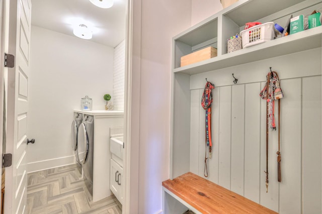 mudroom with light parquet flooring and washer and dryer