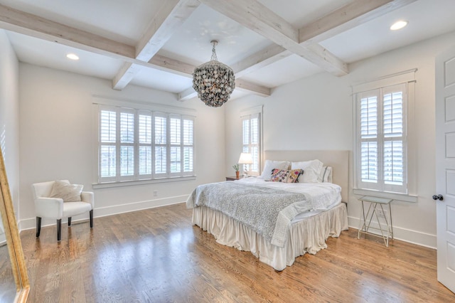 bedroom featuring beam ceiling, a chandelier, wood-type flooring, and coffered ceiling