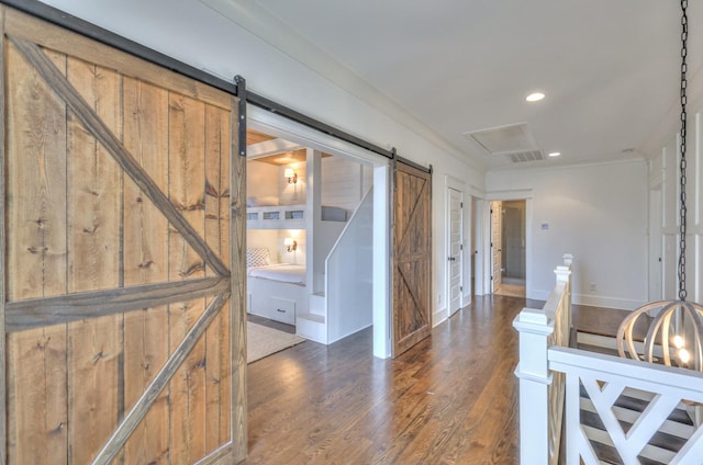 corridor with a barn door and dark wood-type flooring