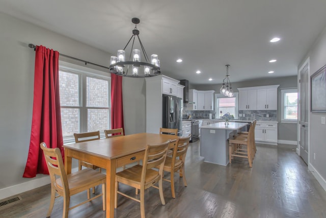 dining space featuring dark hardwood / wood-style floors and a notable chandelier