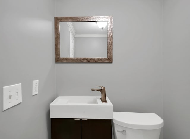 bathroom featuring vanity, toilet, and ornamental molding