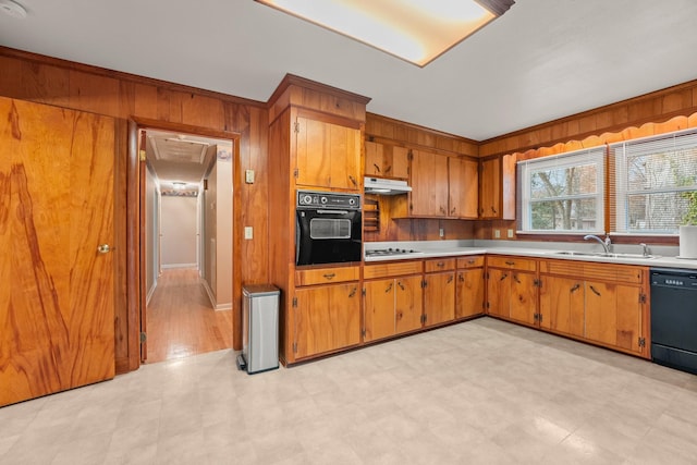 kitchen with wooden walls, sink, and black appliances