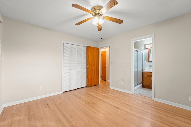 unfurnished bedroom with a closet, ensuite bathroom, light hardwood / wood-style flooring, and ceiling fan