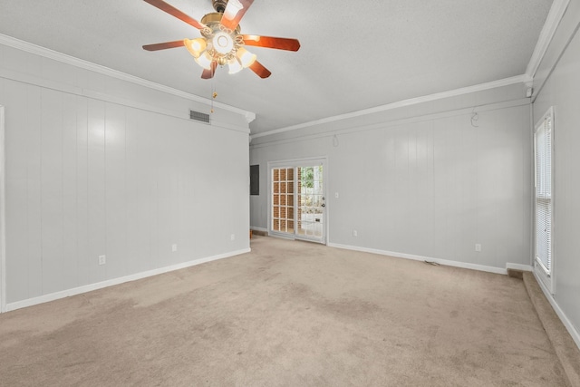 empty room with light carpet, crown molding, ceiling fan, and a textured ceiling