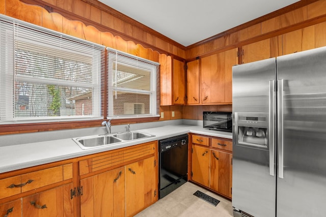 kitchen with sink, a wealth of natural light, crown molding, and black appliances