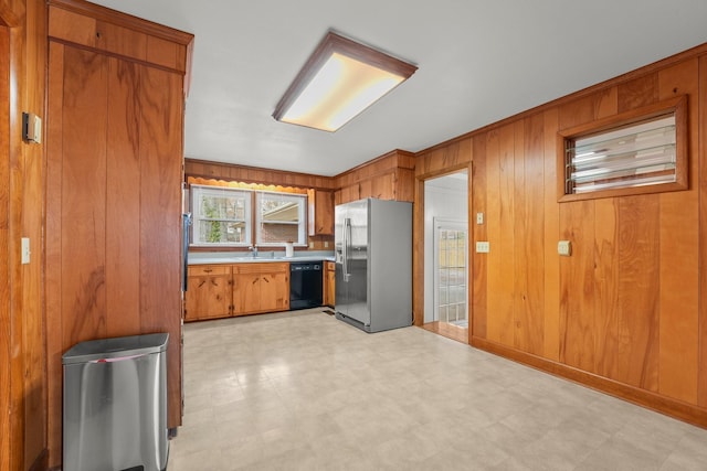 kitchen with stainless steel refrigerator with ice dispenser, ornamental molding, sink, black dishwasher, and wood walls