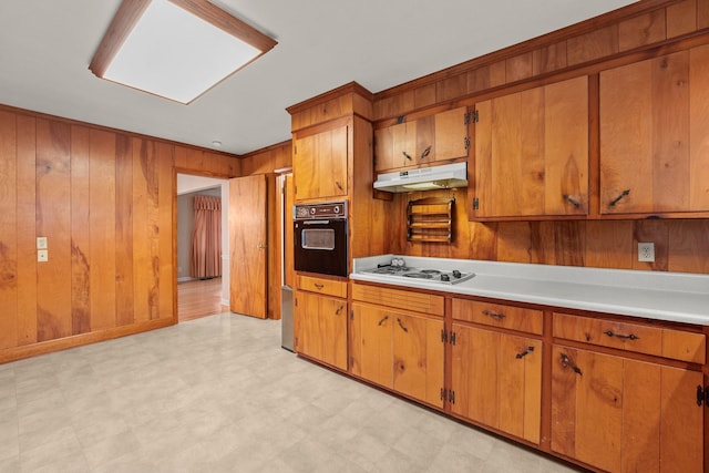 kitchen with oven, white gas stovetop, crown molding, and wooden walls