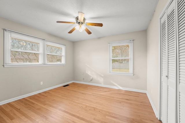 unfurnished bedroom with ceiling fan, light hardwood / wood-style floors, and a textured ceiling