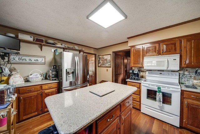 kitchen featuring tasteful backsplash, a textured ceiling, white appliances, hardwood / wood-style flooring, and a center island