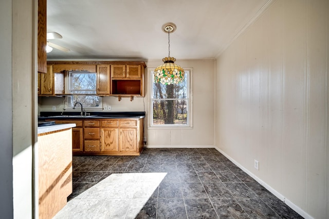 kitchen with ceiling fan, sink, hanging light fixtures, and ornamental molding