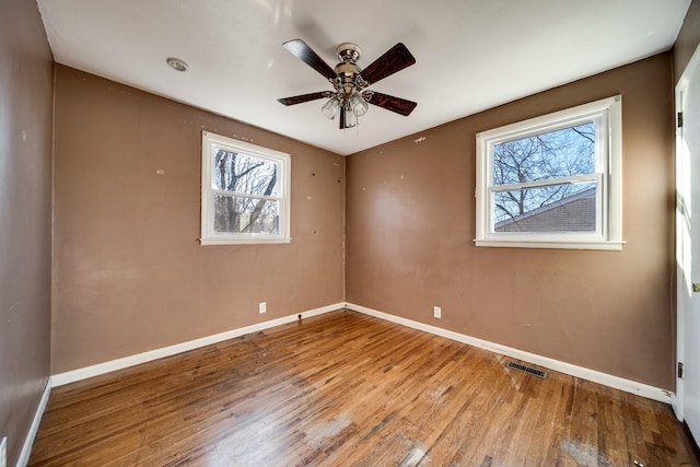 spare room with ceiling fan, light hardwood / wood-style floors, and a wealth of natural light