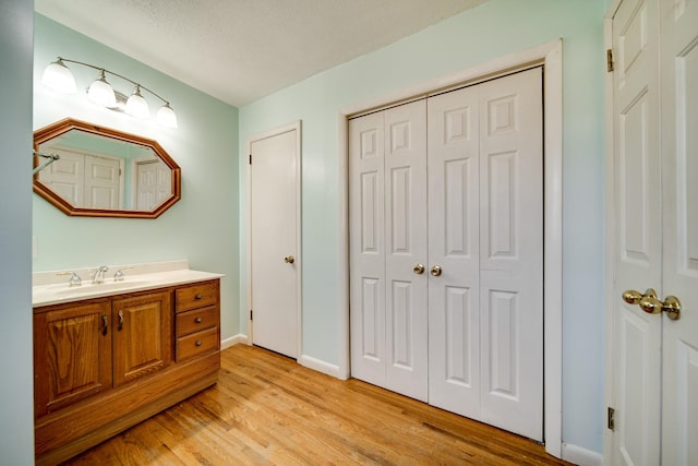 bathroom with hardwood / wood-style floors, vanity, and a textured ceiling