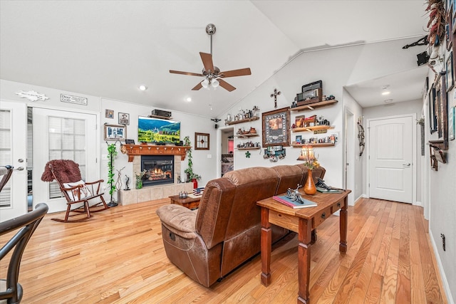 living room featuring a fireplace, light hardwood / wood-style floors, ceiling fan, and lofted ceiling