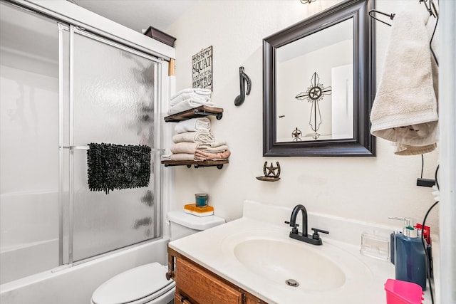 full bathroom featuring vanity, toilet, and shower / bath combination with glass door