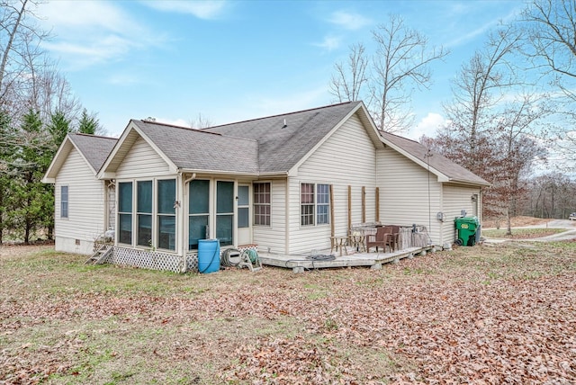 rear view of house featuring a sunroom and a deck