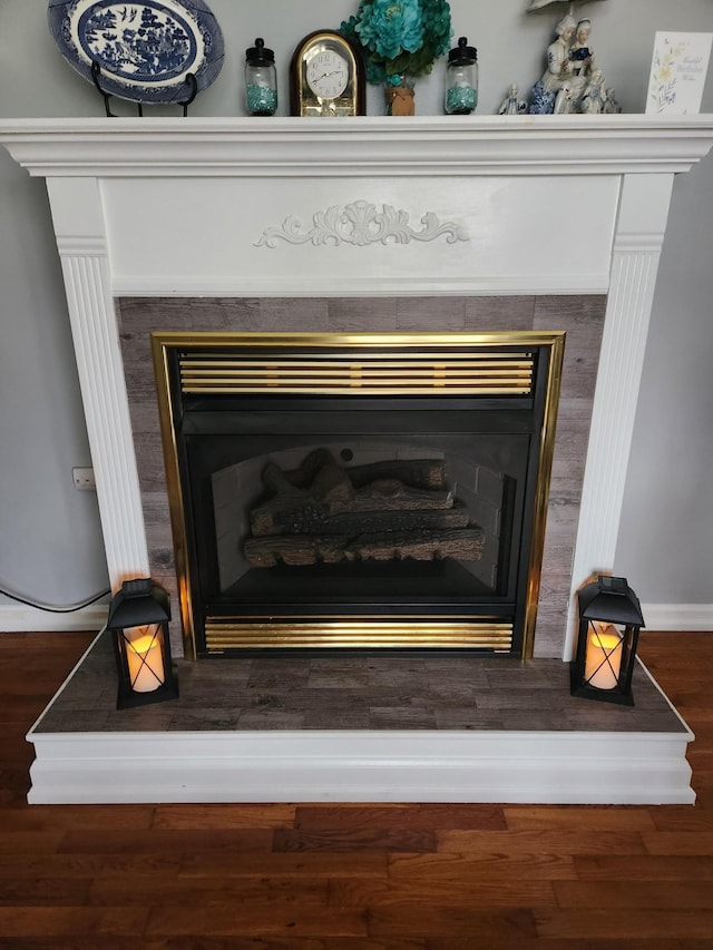 room details featuring hardwood / wood-style flooring and a tile fireplace