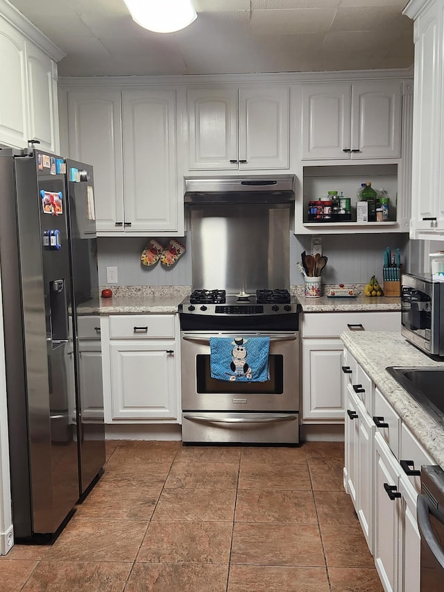 kitchen with white cabinetry, light stone counters, and appliances with stainless steel finishes