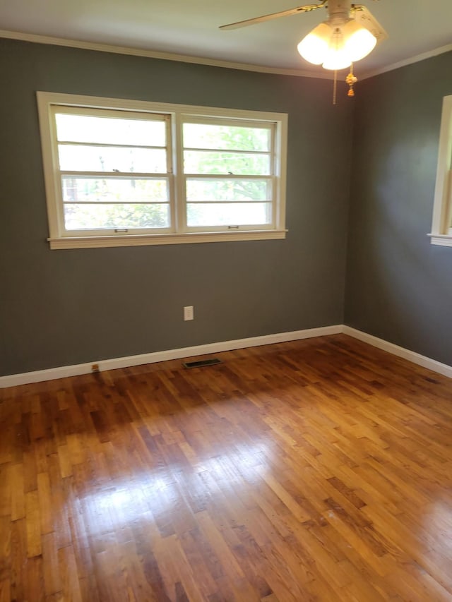 empty room with hardwood / wood-style floors, ceiling fan, and ornamental molding