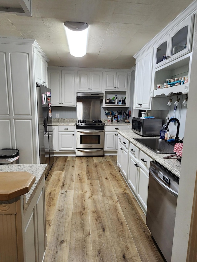 kitchen with stainless steel appliances, white cabinetry, and sink