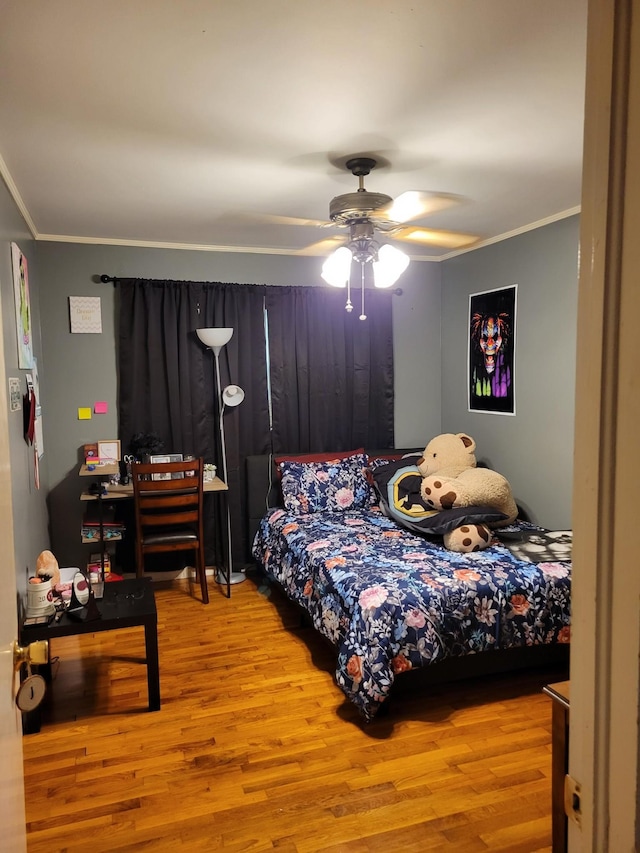 bedroom featuring light hardwood / wood-style floors, ceiling fan, and crown molding