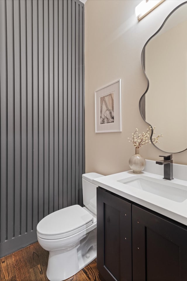 bathroom with hardwood / wood-style floors, vanity, and toilet