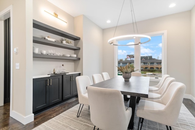 dining space featuring dark hardwood / wood-style floors and an inviting chandelier