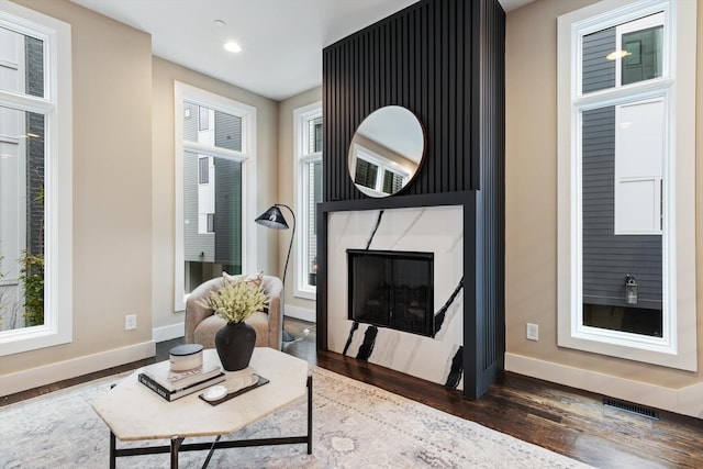 living room with dark hardwood / wood-style flooring and a fireplace