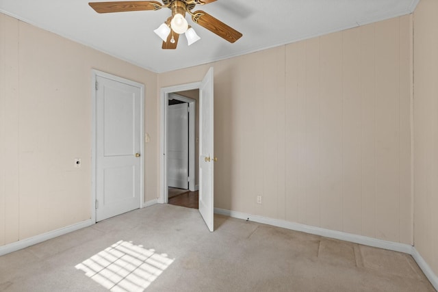 unfurnished room with ceiling fan, light colored carpet, and ornamental molding