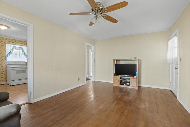 unfurnished living room featuring hardwood / wood-style floors, ceiling fan, and ornamental molding