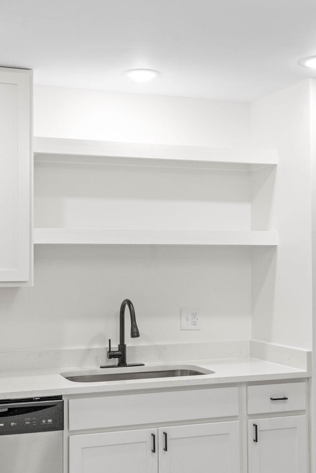 kitchen featuring white cabinets, stainless steel dishwasher, and sink