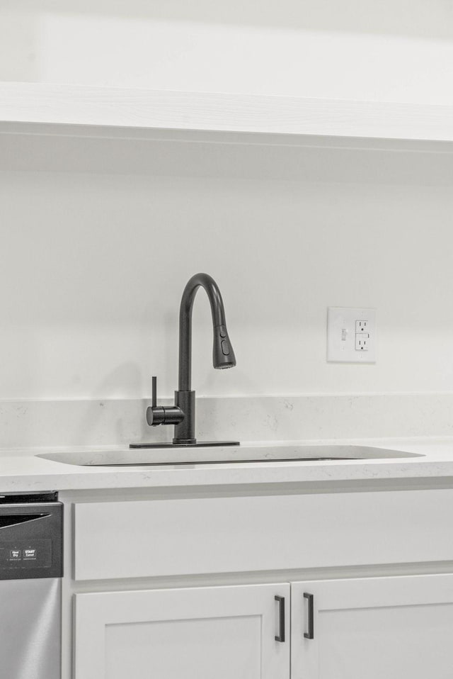 details featuring dishwasher, white cabinetry, and sink