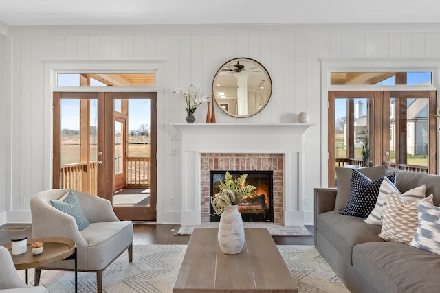 sitting room featuring wooden walls, a fireplace, hardwood / wood-style floors, and french doors