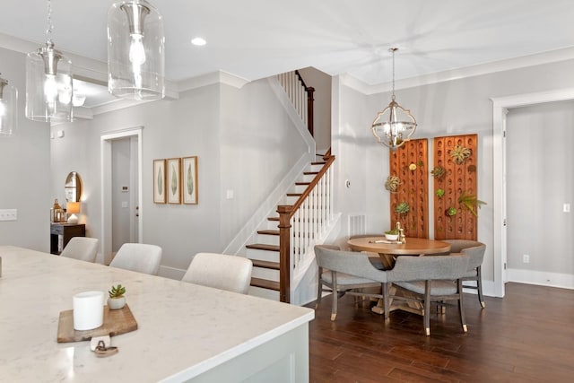 dining room featuring crown molding, dark wood-type flooring, and a notable chandelier