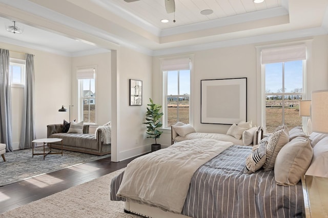 bedroom featuring a tray ceiling, multiple windows, ceiling fan, and dark hardwood / wood-style flooring