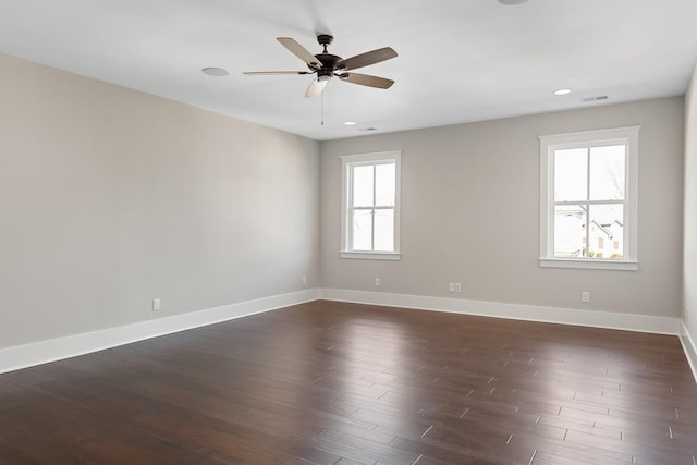 empty room with ceiling fan and dark hardwood / wood-style flooring