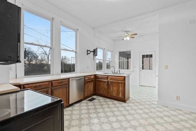 kitchen featuring stainless steel dishwasher, ceiling fan, sink, and a textured ceiling