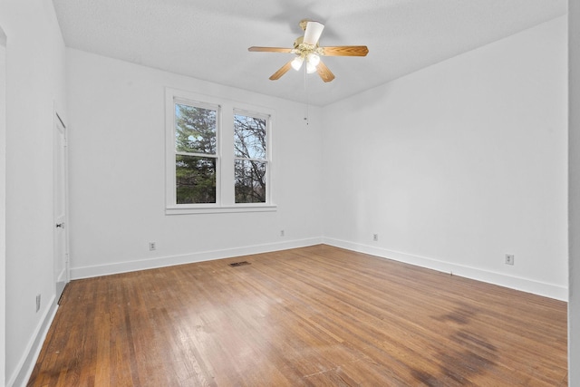 empty room featuring ceiling fan, wood-type flooring, and a textured ceiling