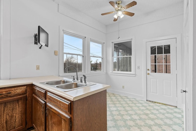 kitchen with a textured ceiling, ceiling fan, kitchen peninsula, and sink