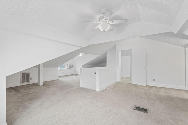 bonus room with a textured ceiling, light colored carpet, vaulted ceiling, and ceiling fan