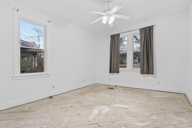 empty room with ceiling fan and light hardwood / wood-style floors