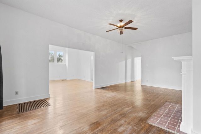 unfurnished living room with a textured ceiling, hardwood / wood-style flooring, and ceiling fan