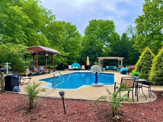 view of swimming pool featuring a pergola and a patio area