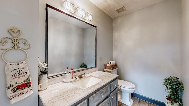 bathroom featuring toilet, vanity, and hardwood / wood-style flooring