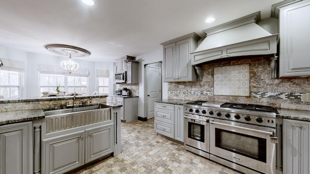 kitchen featuring appliances with stainless steel finishes, tasteful backsplash, gray cabinets, and custom exhaust hood