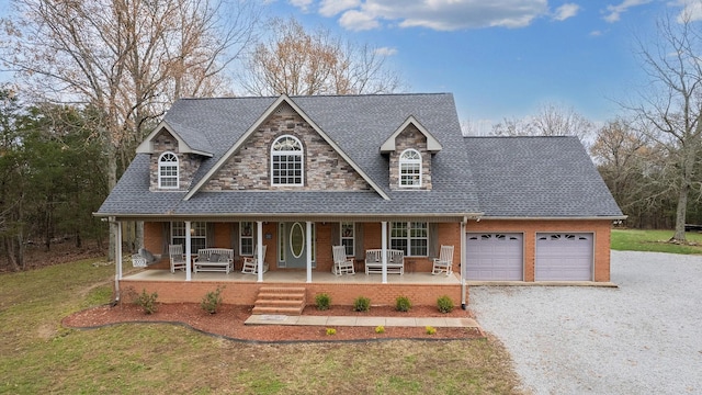 view of front facade with covered porch, a garage, and a front yard